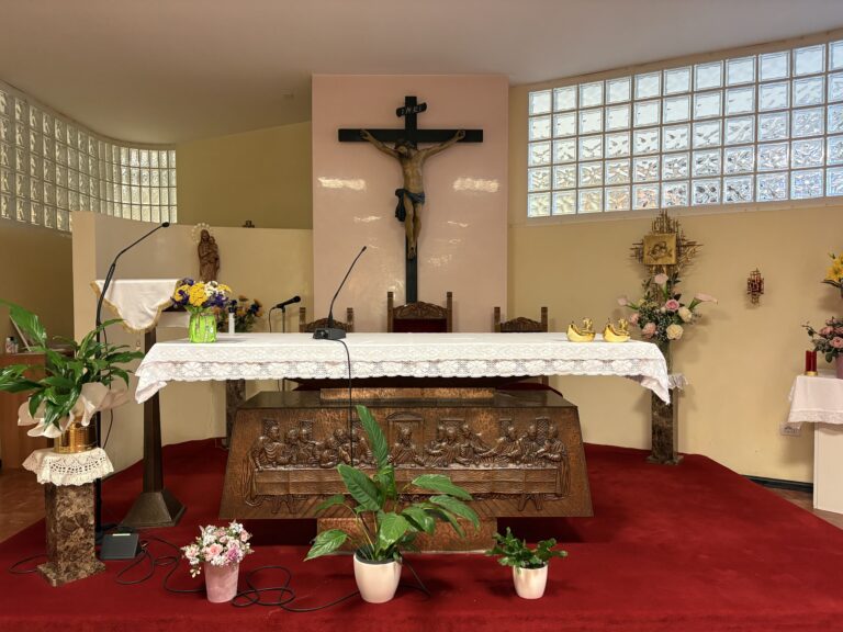 Crocifisso, fiori e sedie ornate in una chiesa con luce naturale e decorazioni sacre