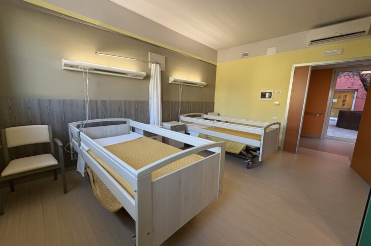 Due letti con tende divisorie e pareti beige