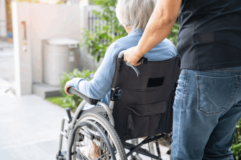 Signore che porta una signora anziana su una carrozzina